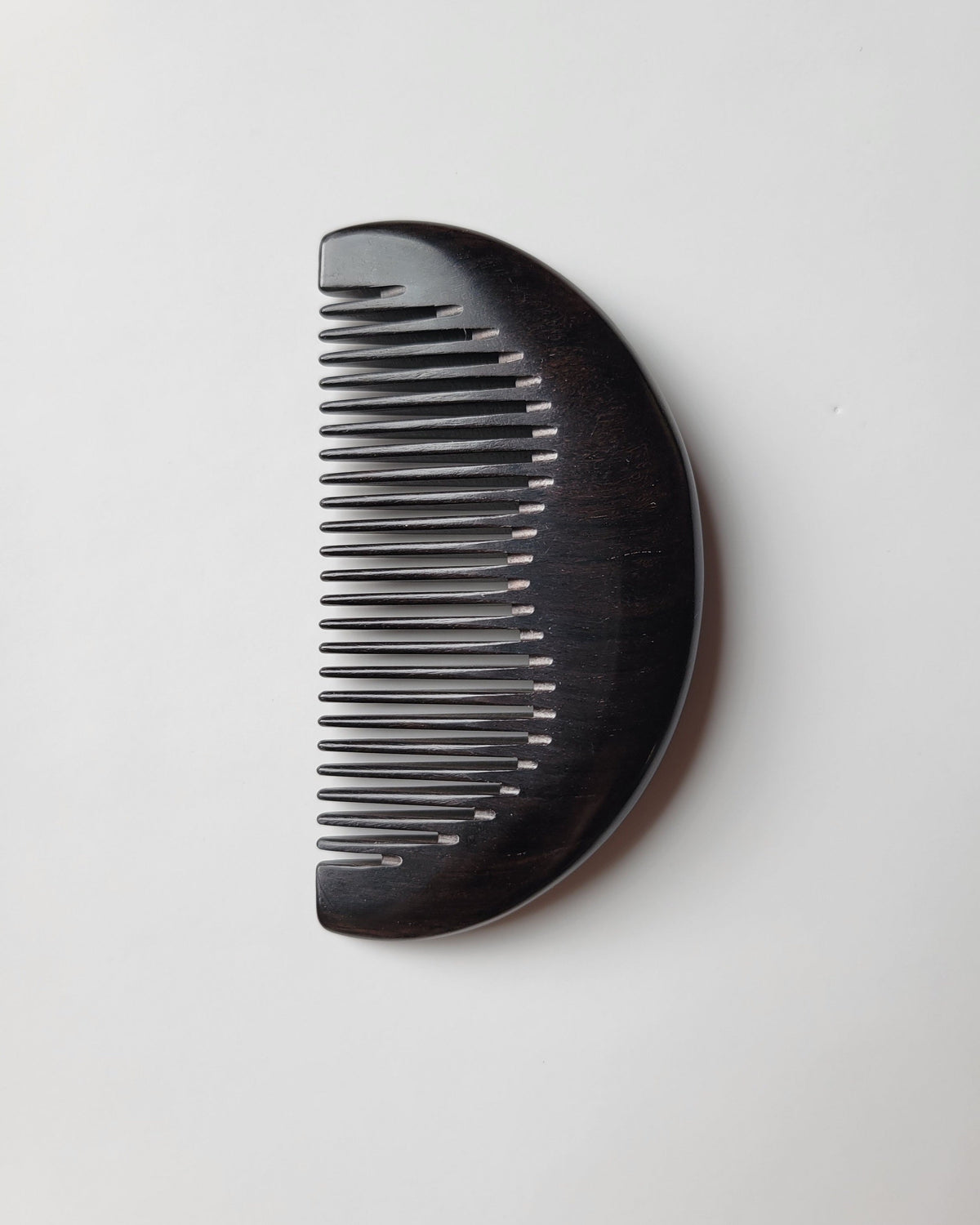 African Ebony half-moon pocket comb with drawstring gift bag, flat lay — a signature gift for him — Arakicrafts