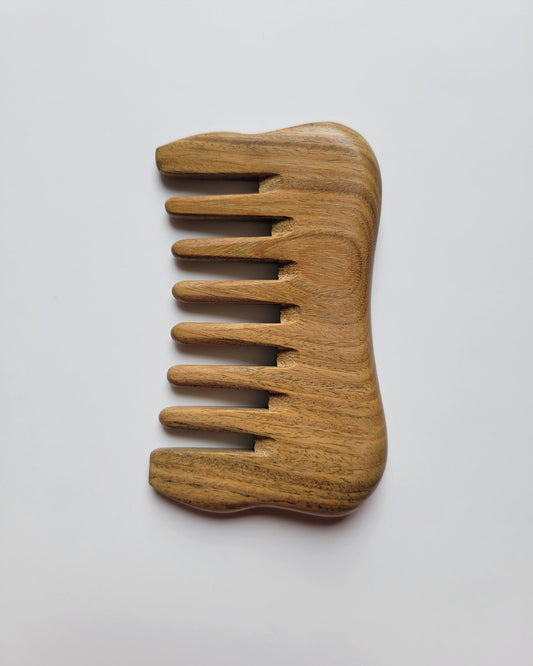 Small sandalwood comb with extra wide teeth. Natural brown color with beautiful wood grain