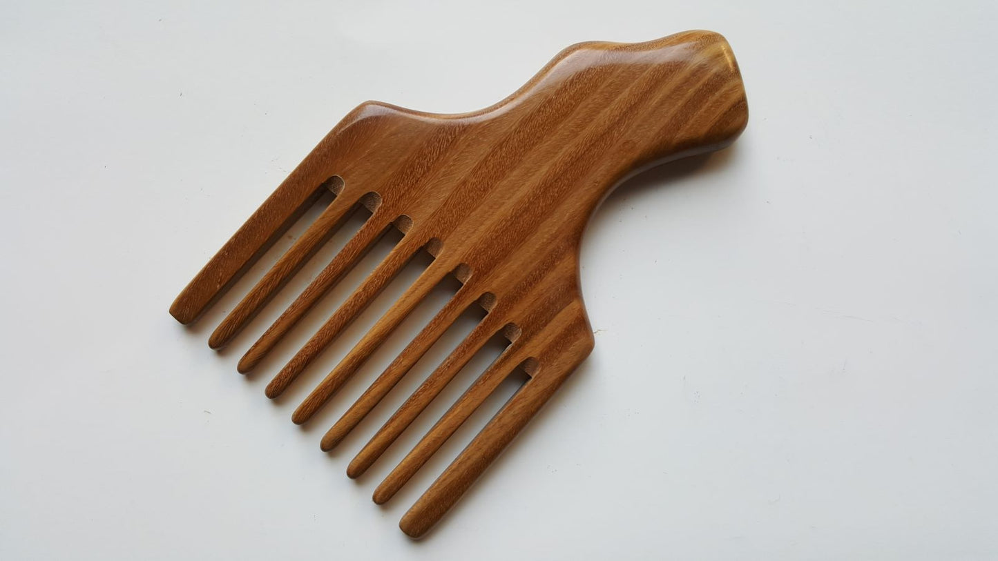 A wooden pick comb with a unique handle design. The comb has 9 teeth and is made of brown sandalwood with a striped pattern. Beautiful one of kind natural comb and great gift. Comes with fabric gift bag.
