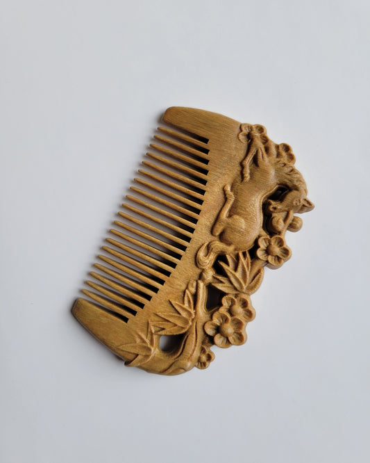 A pocket size wooden comb with a delicate carving. This carving in this comb includes a laying horse, bamboo, and plum blossom. It is inspired by the poem “Parting at Changgan," written by famous Chinese poet Li Bai.