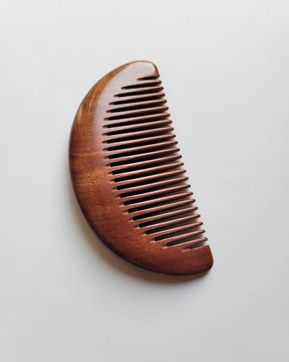 Compact red Mopane pocket comb for women, men, and gentlemen with a minimalist half-moon design