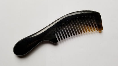 A black comb with a curved handle and fine teeth. The comb's teeth are evenly spaced, and the handle is smooth and rounded. The comb has a smooth finish and is made of buffalo horn.