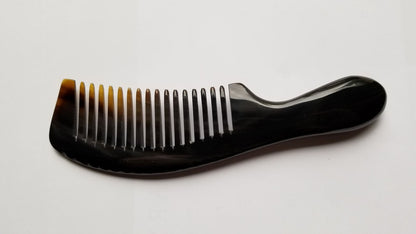 A black horn comb with a curved handle and evenly spaced teeth. The comb is designed for hair care and grooming.  Anti-static and comes with a gift back.
