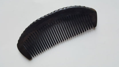 Handcrafted buffalo horn comb — close-up of organic dent handle showing natural horn texture and stripe pattern