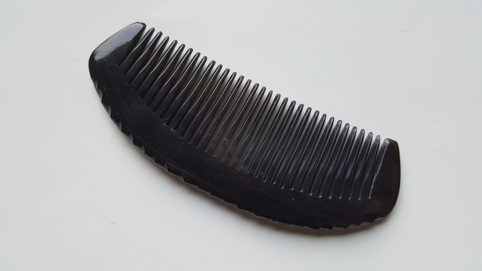 Classic fine-tooth horn comb — flat lay side profile showing 1cm thickness and ergonomic handle shape