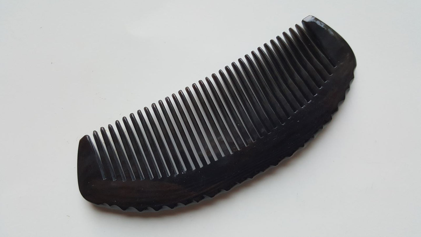 Natural buffalo horn fine-tooth comb — three-quarter angle flat lay showing full length and seamless construction