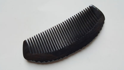 Natural buffalo horn fine-tooth comb — three-quarter angle flat lay showing full length and seamless construction