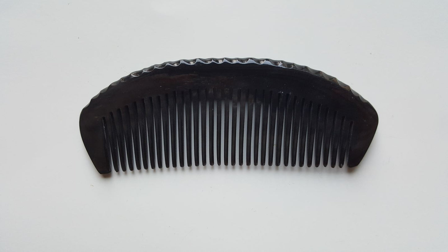 Natural buffalo horn comb — overhead flat lay highlighting fine tooth spacing and horn color variation