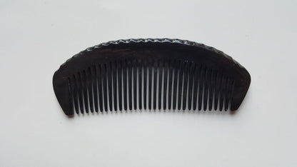 Natural buffalo horn comb — overhead flat lay highlighting fine tooth spacing and horn color variation