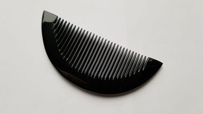 Close-up of half-moon buffalo horn comb teeth — rounded, hand-polished fine teeth detail