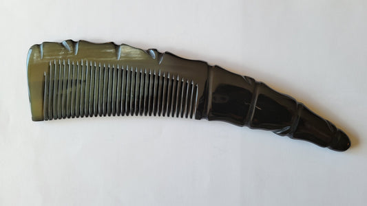 A black horn comb with a glossy finish. The comb has a unique handle design with a spiral pattern and a rounded tip. The teeth are evenly spaced and run the length of the comb.