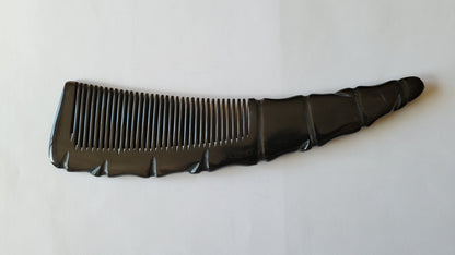  A dark brown horn comb with a unique, textured handle. The comb features closely spaced teeth for men's hair grooming. The handle has a carved, organic design, adding a decorative element to the grooming tool.