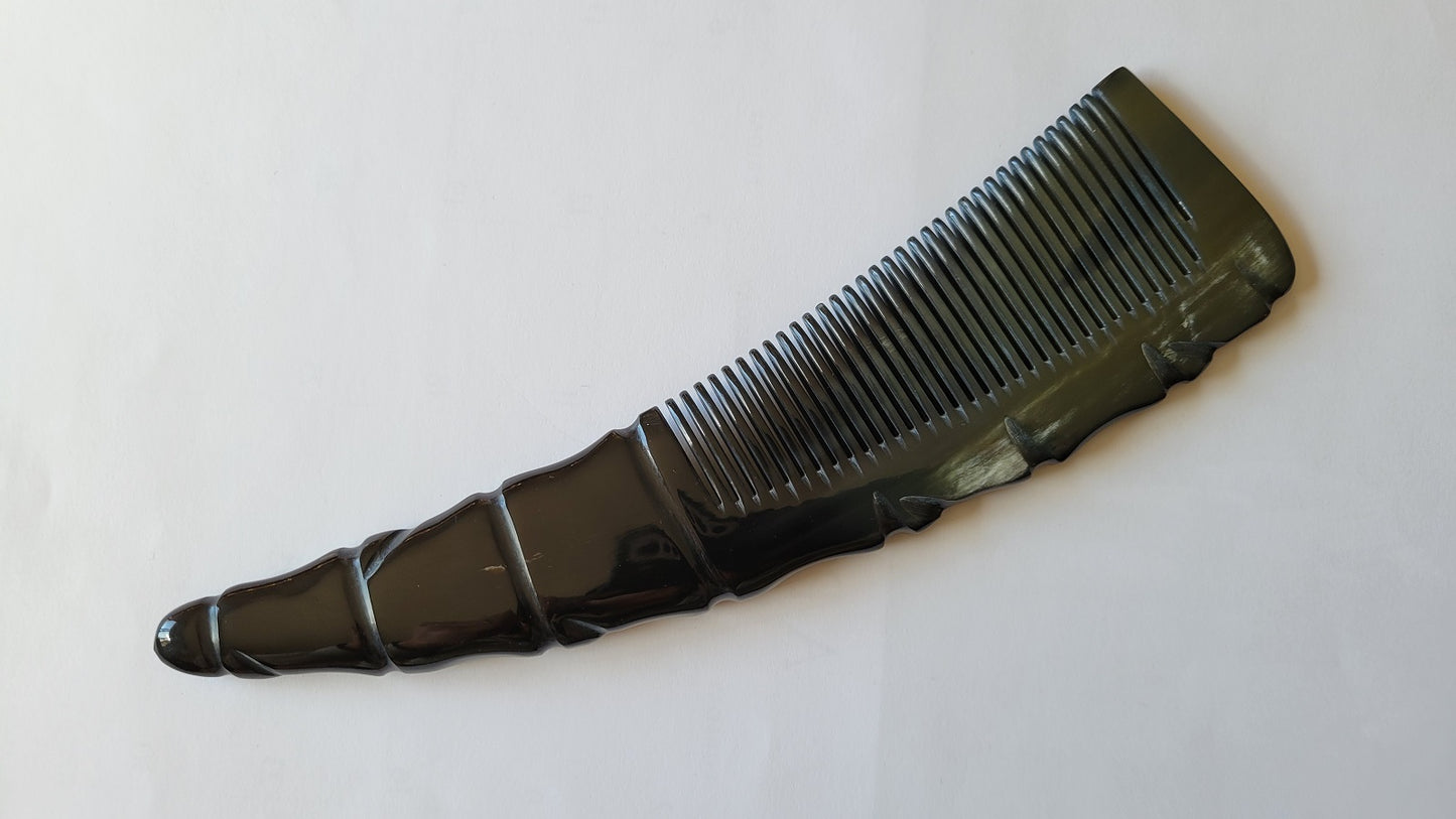 A black horn comb with a unique, textured handle. The comb's teeth are closely spaced, and the handle has a decorative, ridged design. The comb is designed for men's grooming. one of a kind gift for him