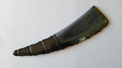 A black horn comb with a unique, textured handle. The comb's teeth are closely spaced, and the handle has a decorative, ridged design. The comb is designed for men's grooming. one of a kind gift for him