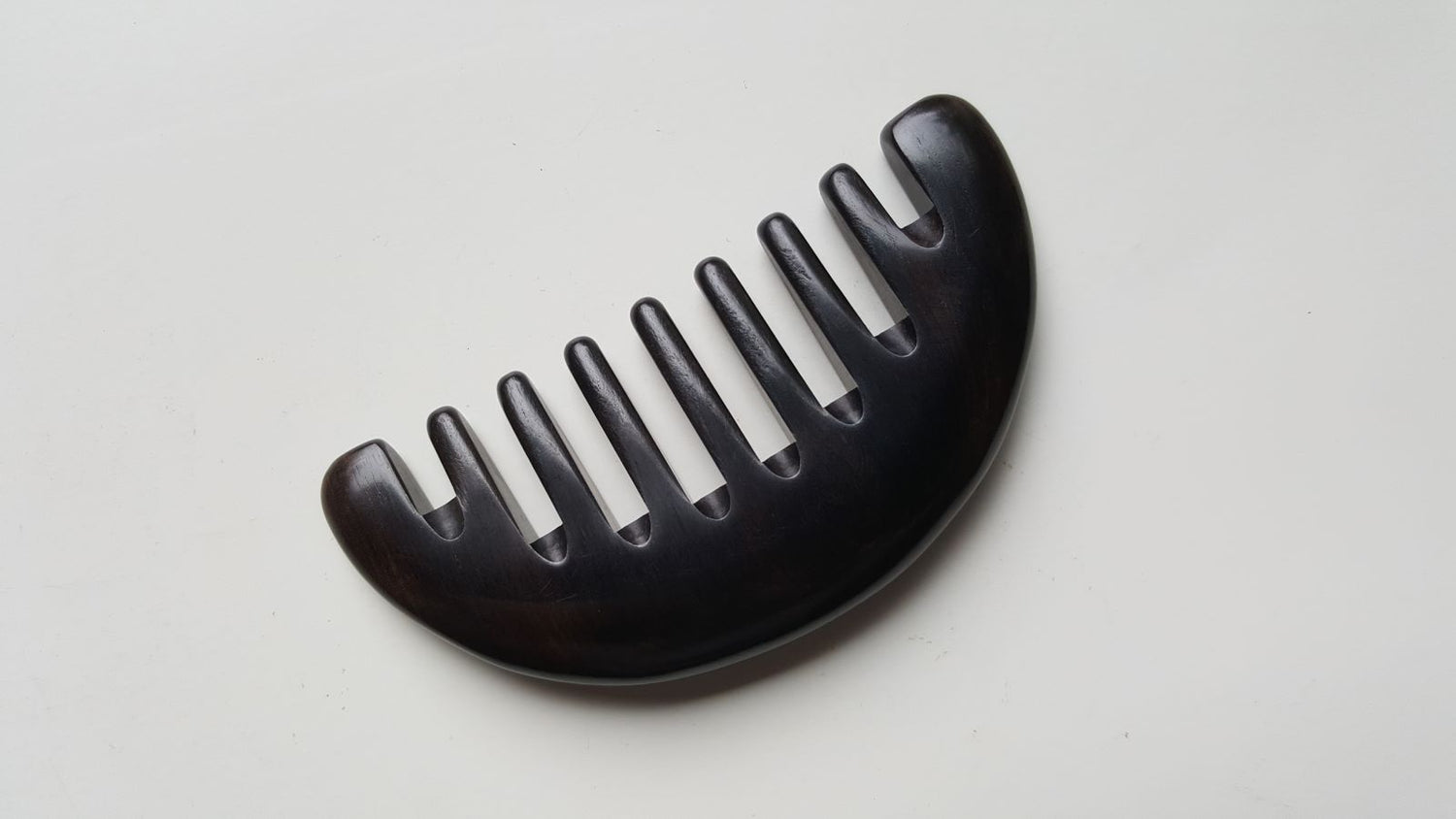 Convex arched spine of African Ebony half moon comb, single-piece hardwood construction, comfortable palm grip | Arakicrafts

