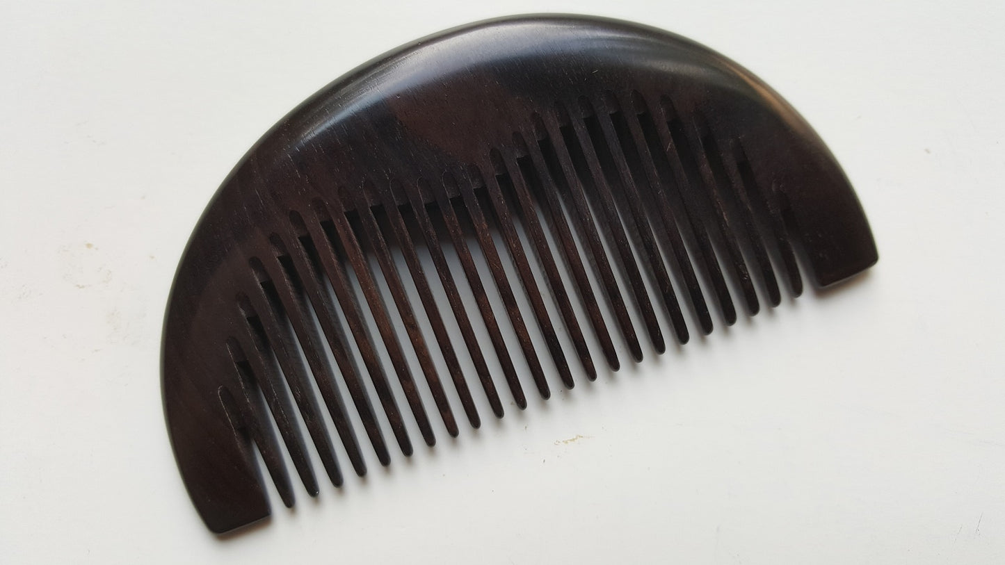 Single-piece African Ebony pocket comb, flat lay side angle showing depth and fine grain — Arakicrafts