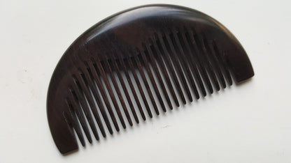 Single-piece African Ebony pocket comb, flat lay side angle showing depth and fine grain — Arakicrafts