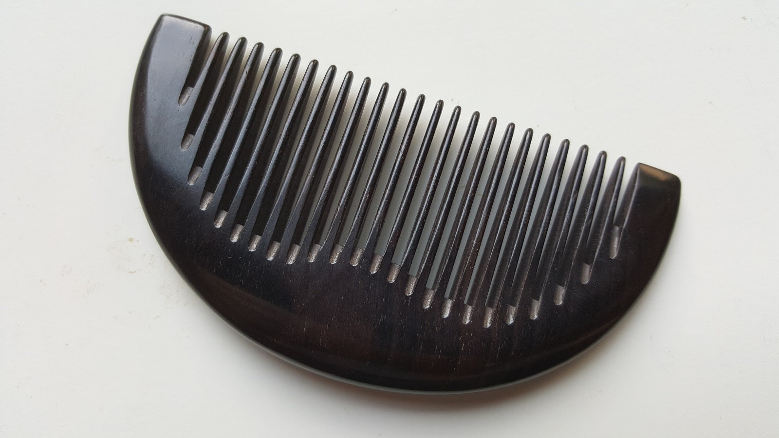 Close-up flat lay of fine teeth on jet-black African Ebony half-moon comb — 0.15 cm tooth spacing — Arakicrafts