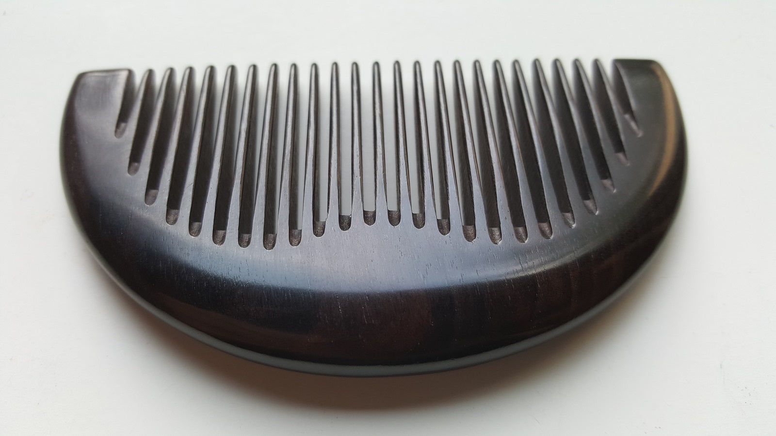 Minimalist half-moon hardwood comb for beard grooming and everyday carry, flat lay — Arakicrafts