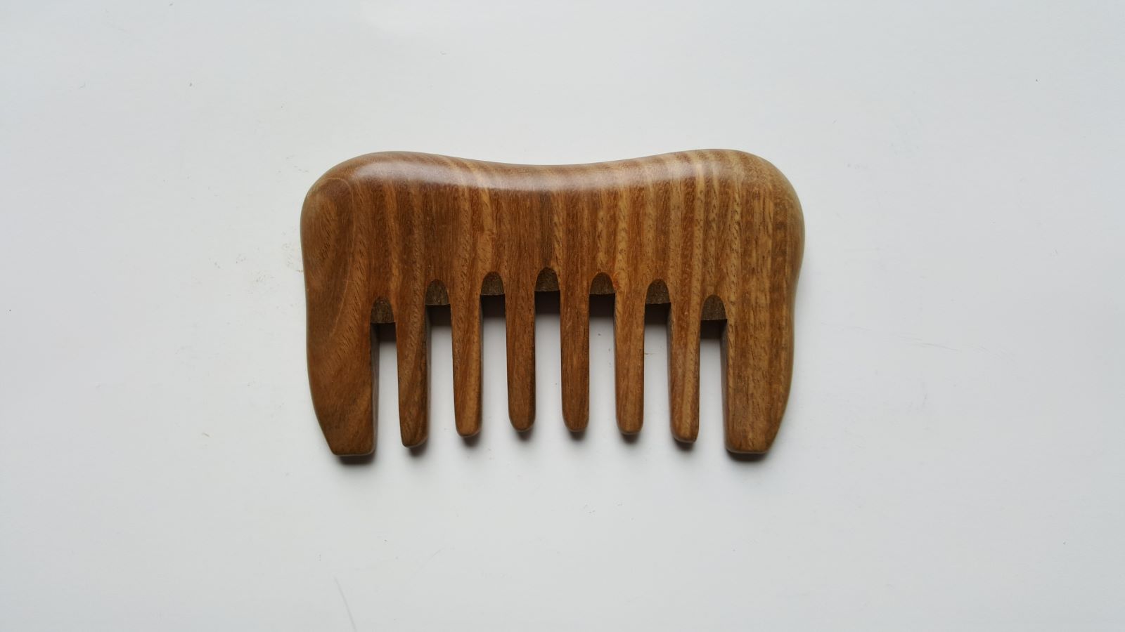 A small detangling sandalwood comb, travel size with carrying bag