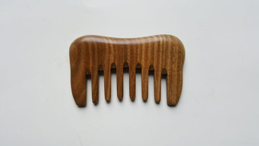 A small detangling sandalwood comb, travel size with carrying bag