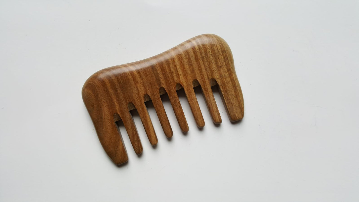 A wooden comb with a natural brown finish and a curved shape. The comb has nine teeth.
