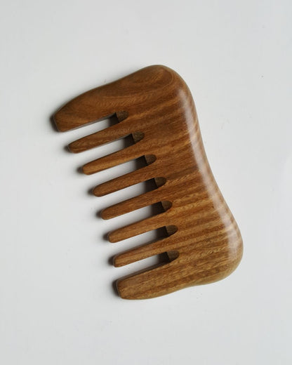 A wooden comb with a natural brown finish and a curved shape. The comb has nine teeth.