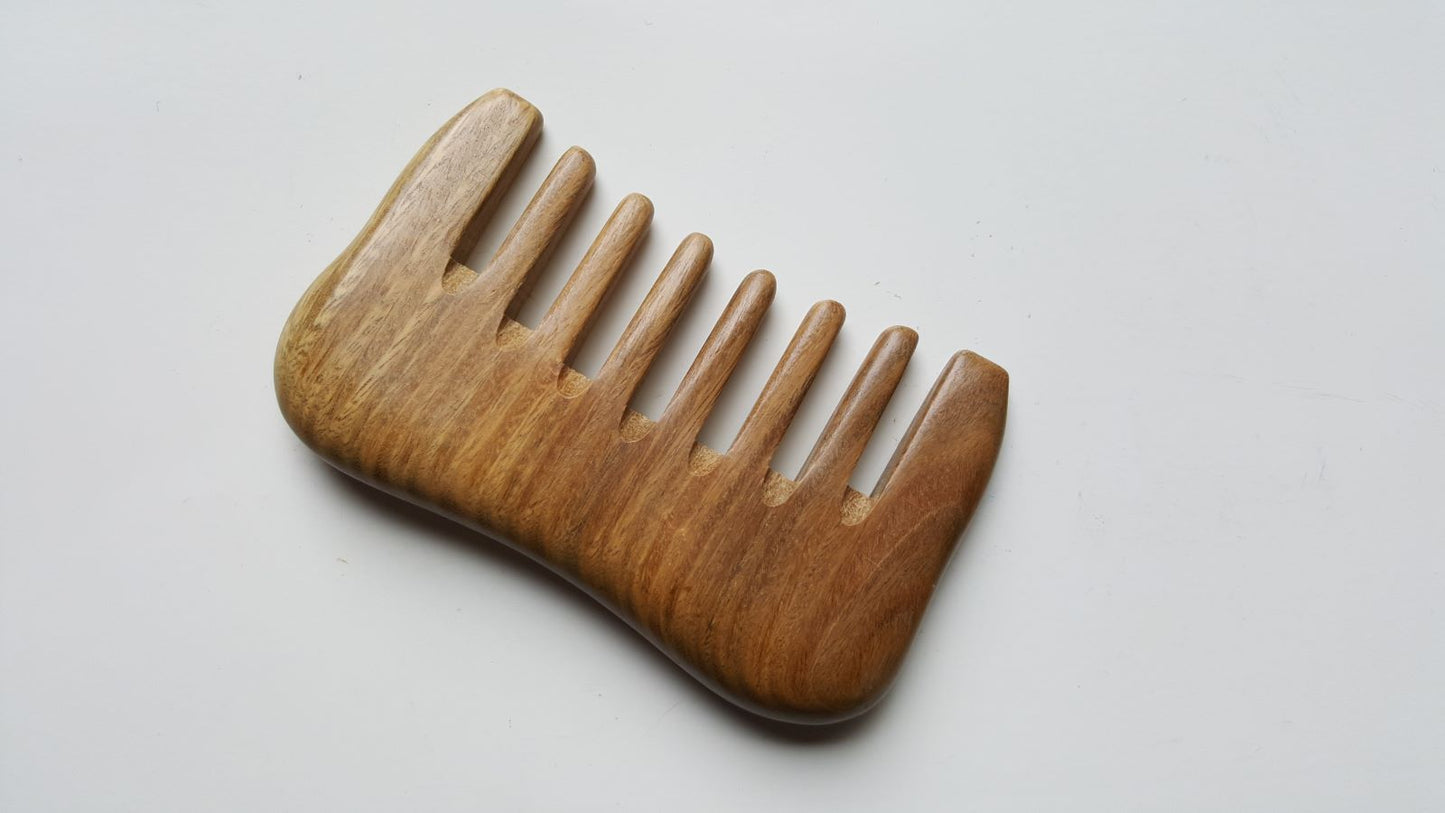 A sandalwood comb with a natural brown finish and a curved shape. This comb is for detangling and massaging. 