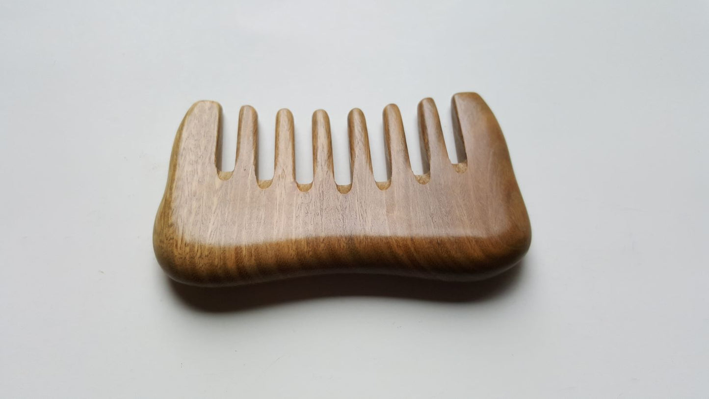 a minimalist style detangling sandalwood comb with 8 extra wide teeth. This wooden comb has a natural brown color and smooth rounded design.  