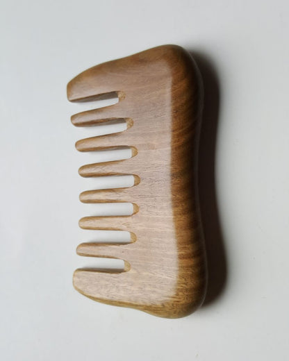 a minimalist style detangling sandalwood comb with 8 extra wide teeth. This wooden comb has a natural brown color and smooth rounded design.