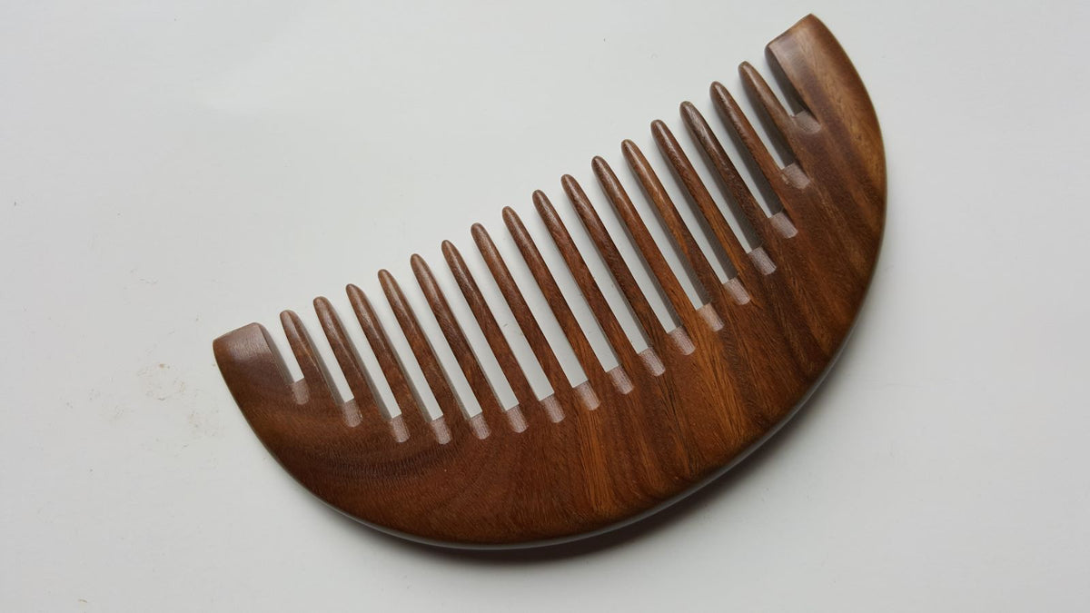 A brown wooden comb with a half-moon shape and nicely spaced wide teeth.  Comes with gift bag and gift ready!