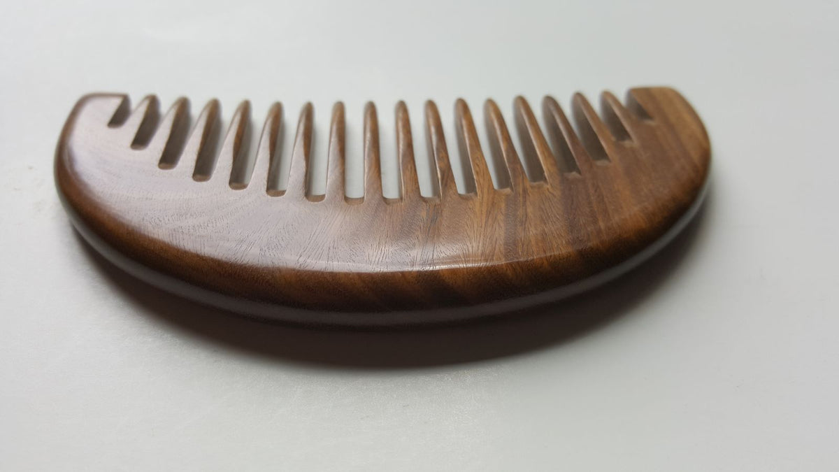Dark brown half moon shaped green sandalwood comb — lay flat view. Wide teeth, anti-static, eco-friendly and zero waste.