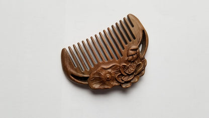 A mini hand carved comb with a lotus design. The comb is made of sandalwood, eco beauty, healthy hair care comb