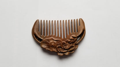 A mini hand carved comb with a lotus design. It has a row of evenly spaced teeth on one side and is made of sandalwood.  travel size and comes with a fabric gift bag. Perfect gift for her