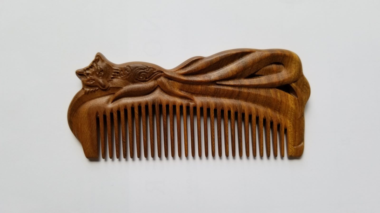A beautiful hand carved Fox Design Vintage Style sandalwood Comb — front view