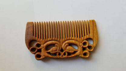 East Asian Phoenix Sandalwood Comb flat lay — overhead view showing full pocket-sized comb and hand-carved phoenix motif on both sides