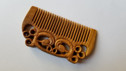 East Asian Phoenix Sandalwood Comb flat lay — angled view emphasizing green sandalwood color and symmetrical phoenix carving