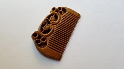 East Asian Phoenix Sandalwood Comb flat lay — close view of hand-carved symmetrical phoenix pattern on green sandalwood surface. a  great gift for her for any special occasion. 