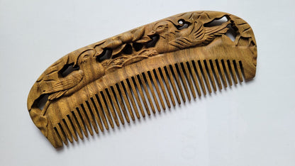 Mandarin Duck Hand Carved Sandalwood Comb flat lay — three-quarter view showing hand-carved floral and duck motif and natural sandalwood grain