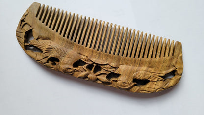 Mandarin Duck Hand Carved Sandalwood Comb flat lay — angled view emphasizing green sandalwood color and hand-carved mandarin duck motif