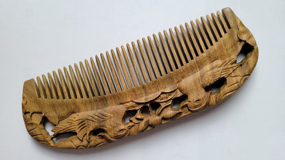 Mandarin Duck Hand Carved Sandalwood Comb flat lay — diagonal angle showing fine teeth and carved mandarin duck detail on sandalwood