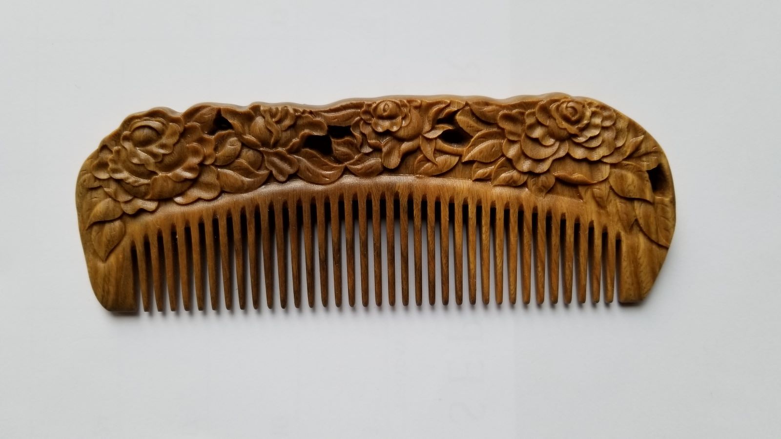Rose Hand Carved Sandalwood Comb flat lay — front view showing hand-carved blooming rose pattern and fine teeth on green sandalwood