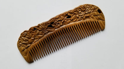 Rose Hand Carved Sandalwood Comb flat lay — three-quarter view showing hand-carved floral pattern and natural sandalwood grain