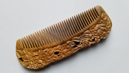 Rose Hand Carved Sandalwood Comb flat lay — diagonal angle showing fine buffalo horn teeth and carved floral detail