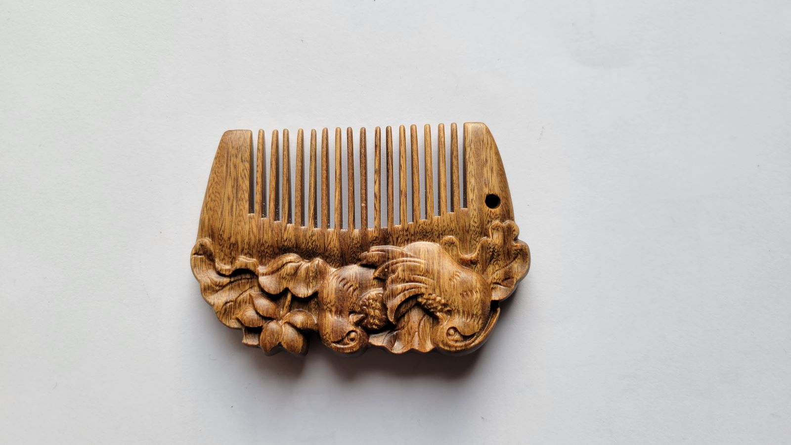 Mandarin duck hand carved comb angled left, showing carved duck motif detail on sandalwood