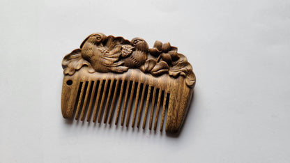 Mandarin duck wood comb standing upright, profile view showing slim 1cm thickness