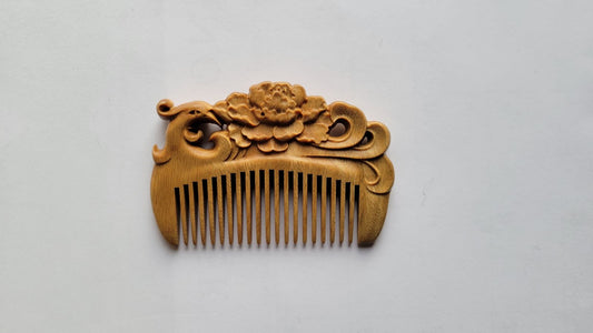 Wooden comb with phoenix and floral design on a light gray background from arakicrafts