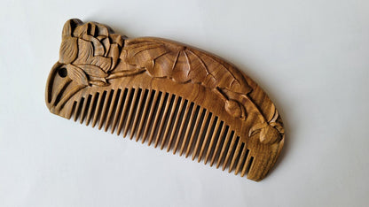 Close-up of lotus bud and leaf relief carving on brown Green Sandalwood comb — artisan Tongjing technique — Arakicrafts