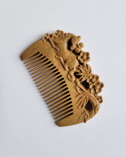 A light brown vintage style wooden comb with carving. The horse, bamboo and plums motif are on both sides of this comb. It implies "childhood sweethearts" or "a couple who grew up as childhood friends."