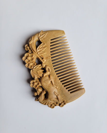 A light brown vintage style wooden comb with carving. The horse, bamboo and plums motif are on both sides of this comb. Comes with gift bag